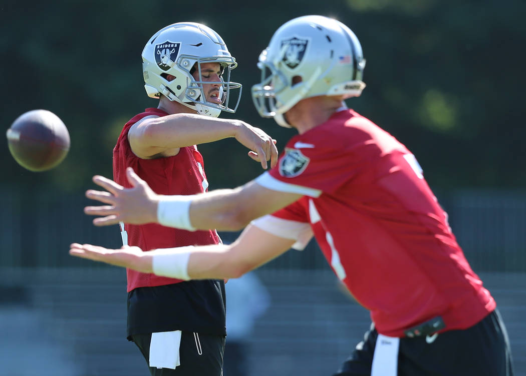 Oakland Raiders quarterback Derek Carr (4) dances as quarterback Mike Glennon (7) reaches out t ...