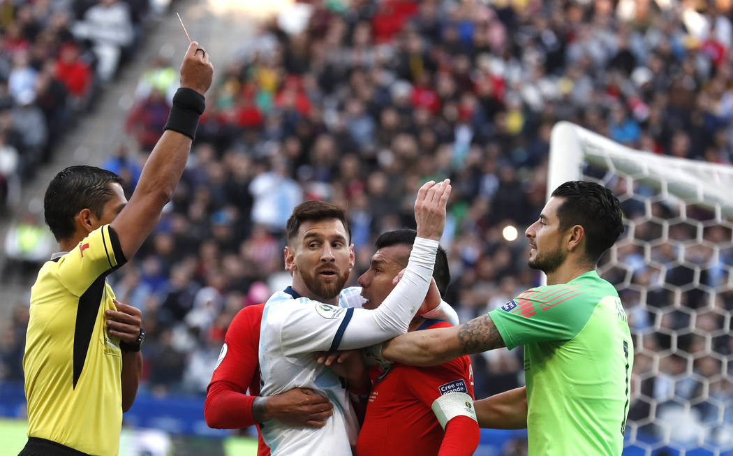 Argentina's Lionel Messi, center left, and Chile's Gary Medel, center right, scuffle as referee ...