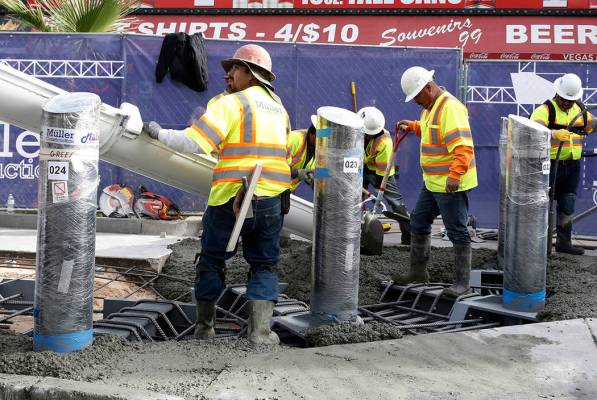 Construction crews pour cement where they began installing steel posts on the Strip near Aria h ...