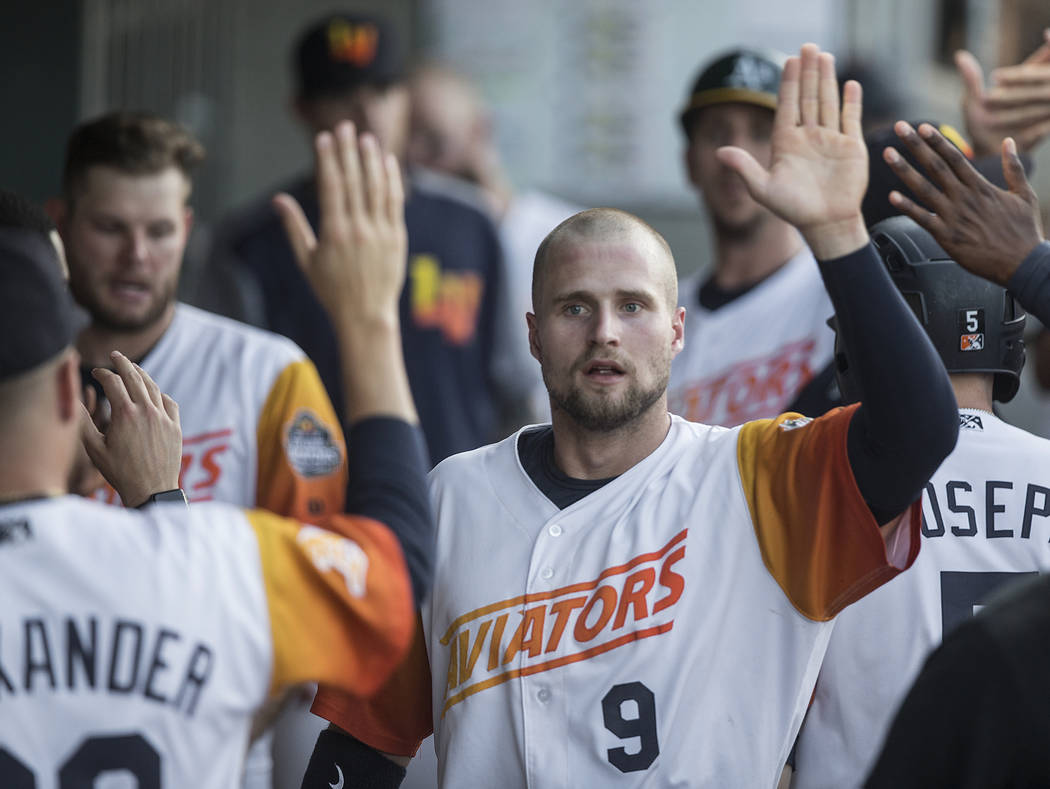 Las Vegas Aviators first baseman Seth Brown (9) high fives his teammates after scoring in the b ...