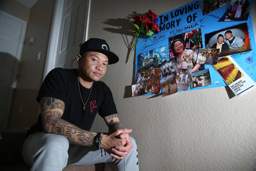 Jerome Penaranda sits besides a collection of photos dedicated to his mother at his home, Thurs ...