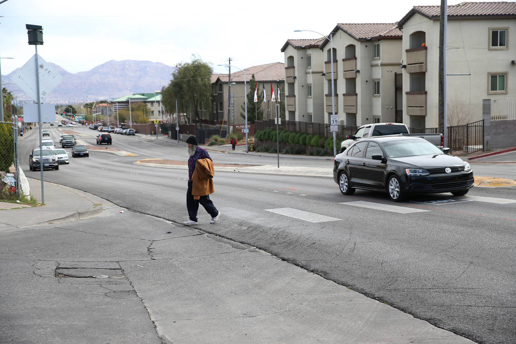 Homeless man Timothy Hamett crosses the intersection of W. Owens Avenue and Stocker Street, acr ...