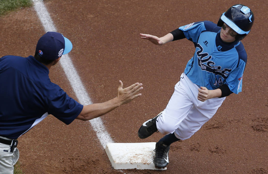 FILE - In this Aug. 17, 2014, file photo, Las Vegas' Brad Stone, right, rounds third to greetin ...