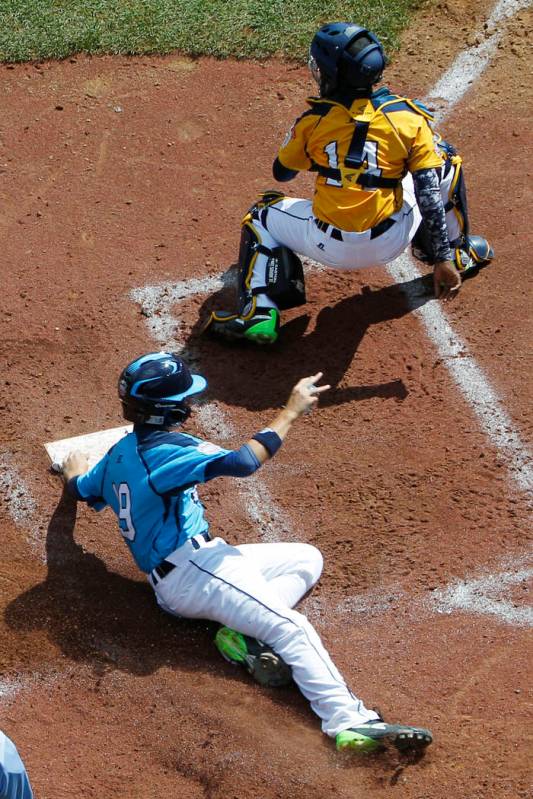 Las Vegas' Zach Hare, bottom, scores behind Chicago catcher Brandon Green (14) on a single by B ...