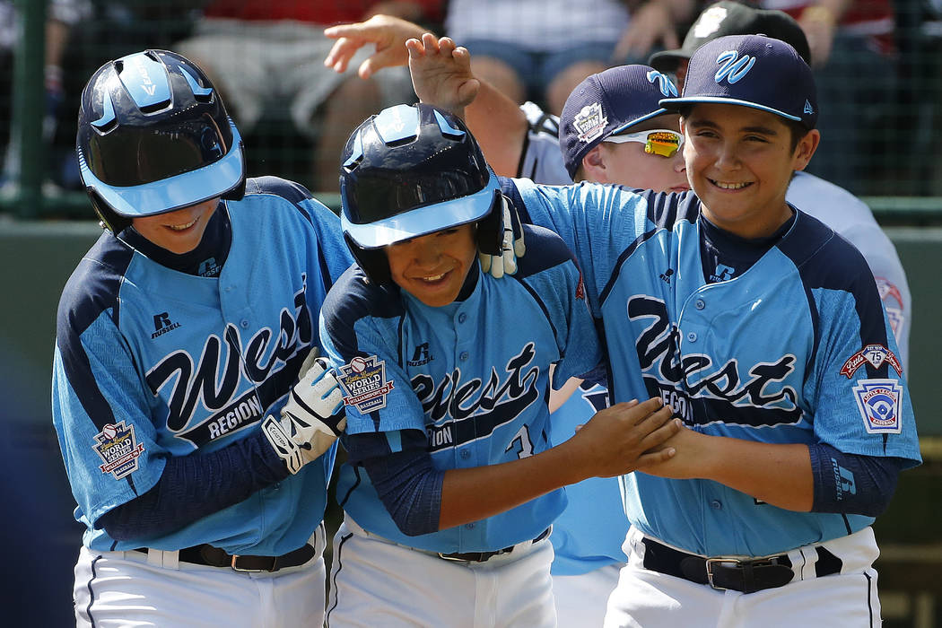 Las Vegas' Dominic Clayton, center, celebrates with teammates Josh Zuehlsdorff, left, and Dillo ...