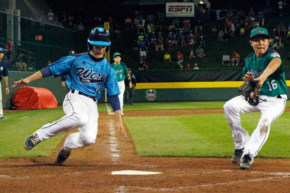 Las Vegas' Austin Kryszczuk, left, scores on a wild pitch by Rapid City, South Dakota pitcher D ...