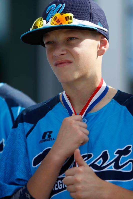 Mountain Ridge Little League player Justin Hausner (5) stands during a ceremony to honor the te ...