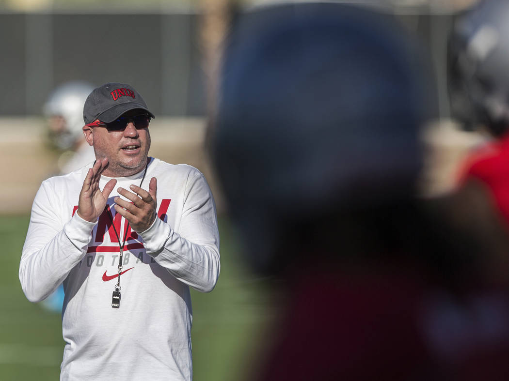UNLV head football coach Tony Sanchez, left, fires up his team during the first day of training ...