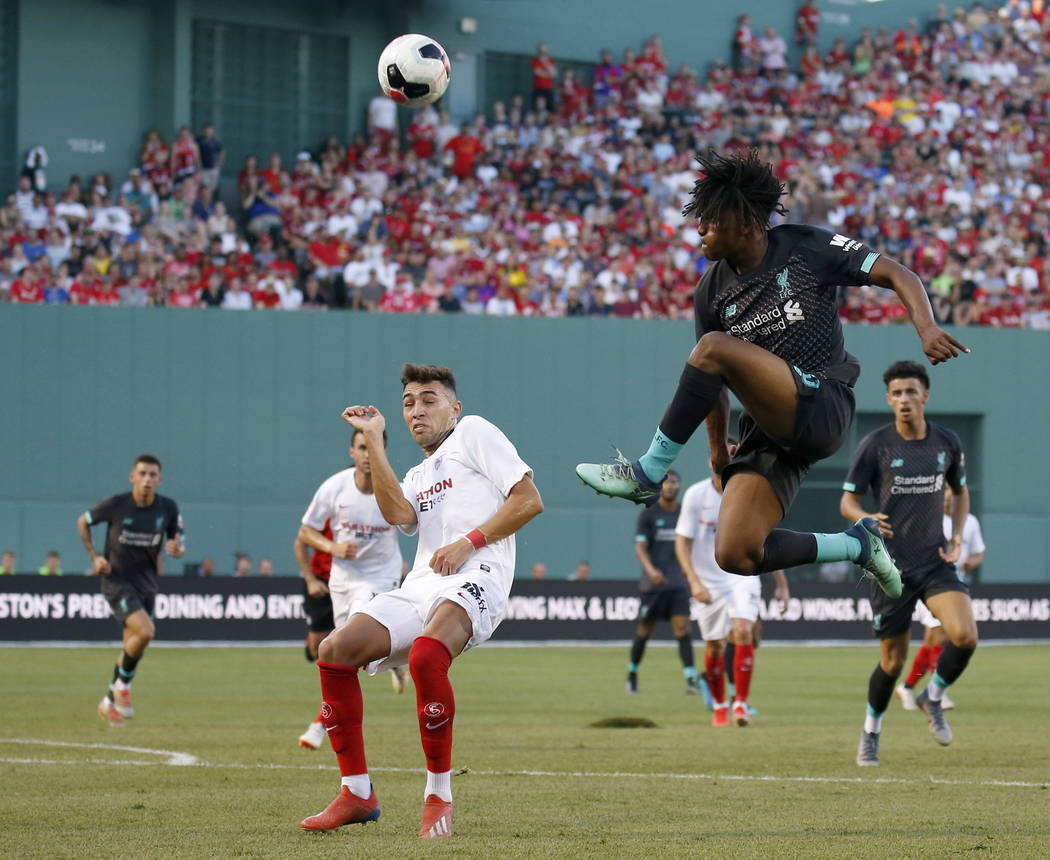 Liverpool's Yasser Larouci, front right, jumps for a ball against Sevilla's Munir during the se ...