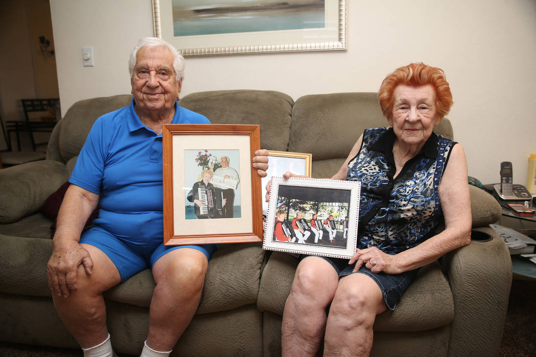 Joe Baykara, left, 93, and his wife Etta, 91, pose for a portrait with family photos at their h ...