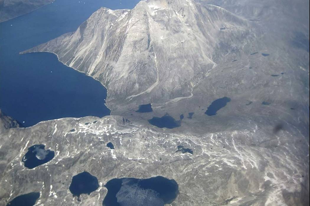 In this image taken on June 22, 2019, an aerial view of melt water lakes on the edge of an ice ...