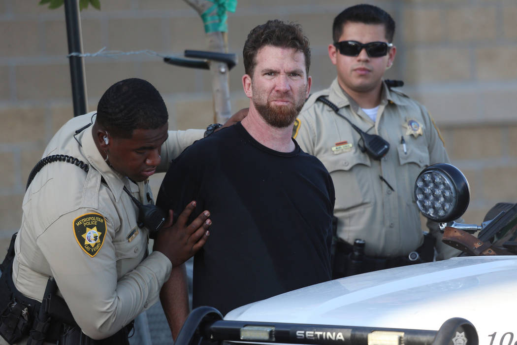 A man is escorted by Las Vegas police officers at the Smith's Marketplace, at 9710 West Skye Ca ...