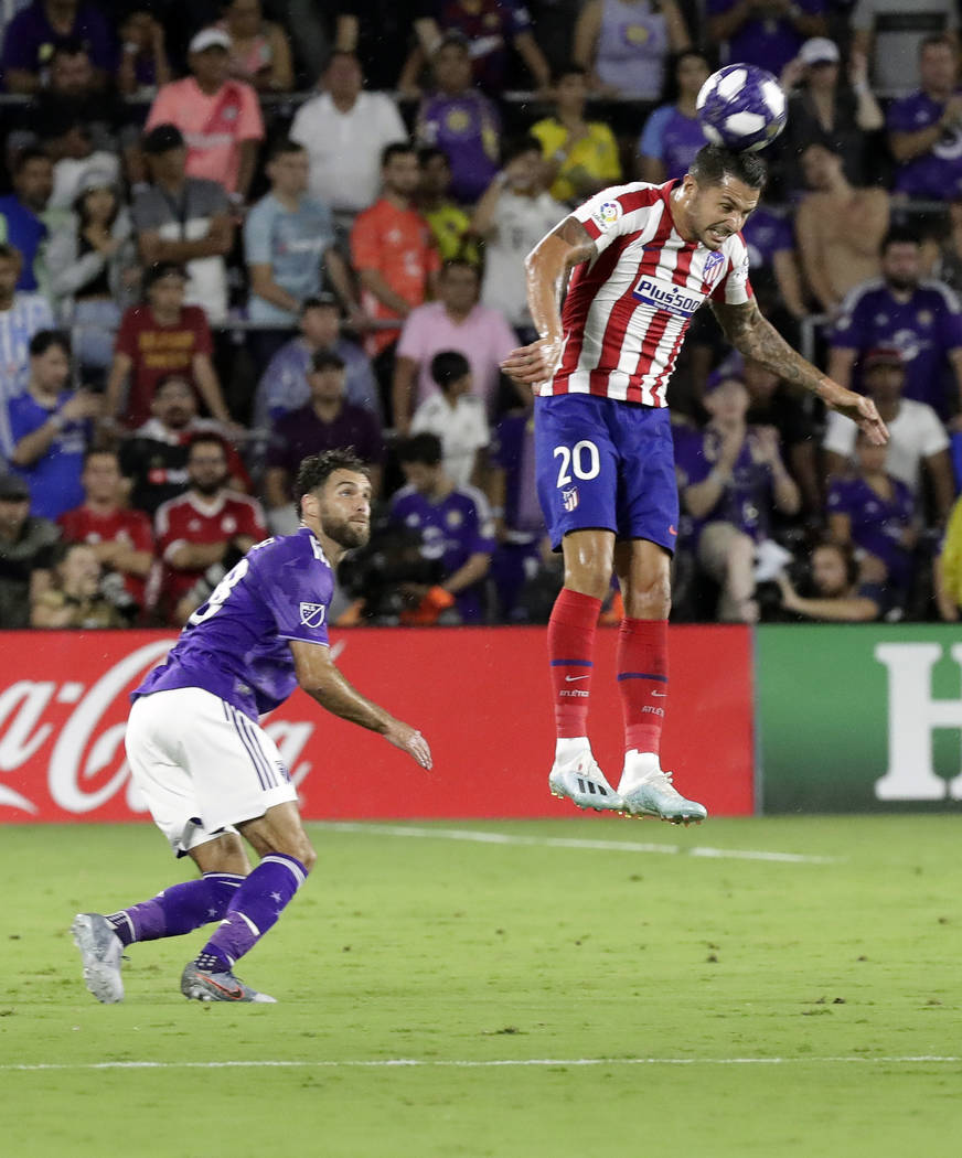 Atletico Madrid midfielder Vitolo (20) clears the ball away from Sporting Kansas City defender ...