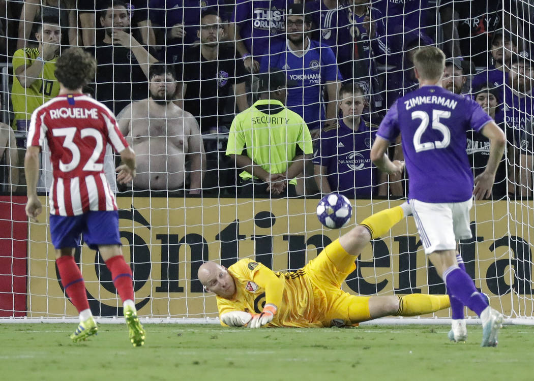 Atlanta United goalkeeper Brad Guzan, center, blocks a shot by Atletico Madrid midfielder Rodri ...