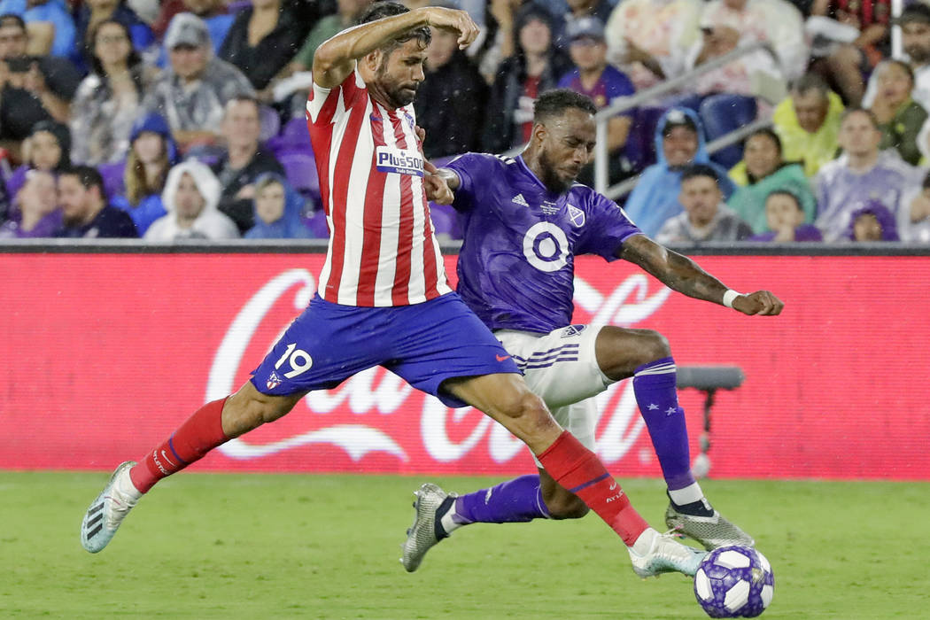 Atletico Madrid forward Diego Costa (19) pushes the ball past Minnesota United defender Romain ...