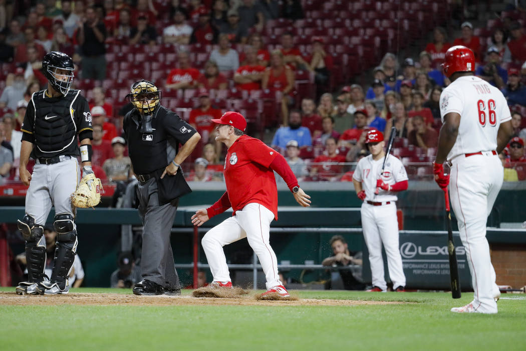 Cincinnati Reds manager David Bell (25) runs to argue with umpire Larry Vanover, center, over a ...