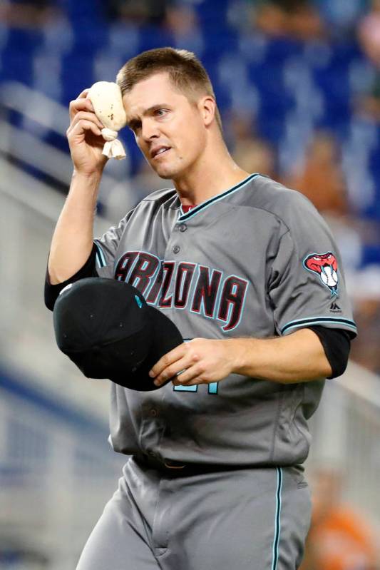 Arizona Diamondbacks starting pitcher Zack Greinke wipes his forehead with the rosin bag during ...