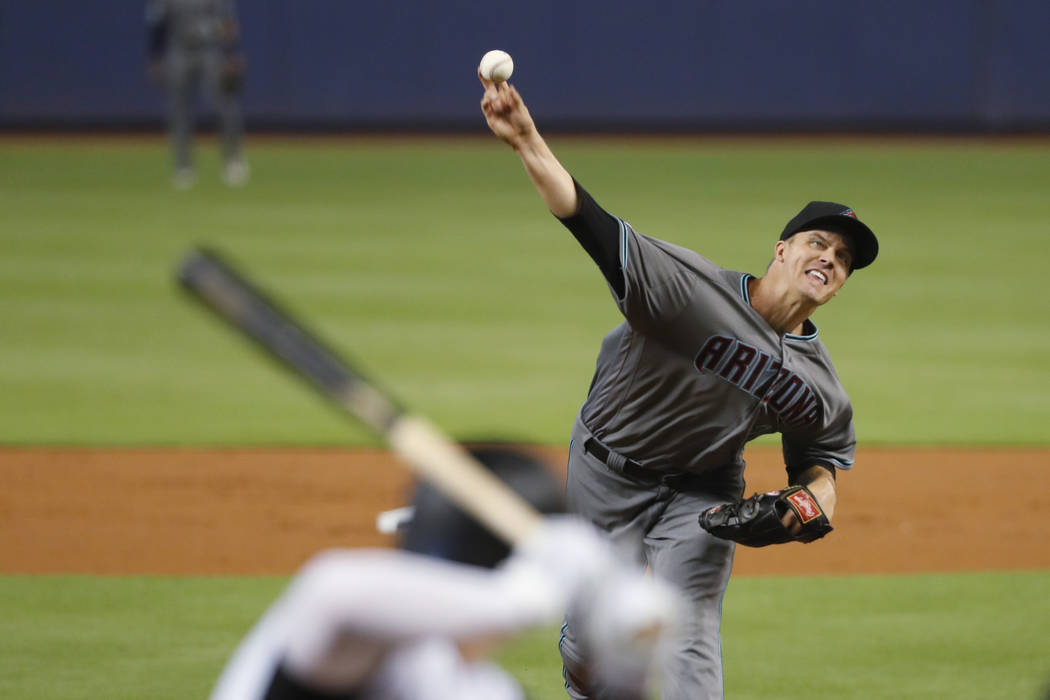 Arizona Diamondbacks' Zack Greinke, right, pitches to Garrett Cooper during the first inning of ...