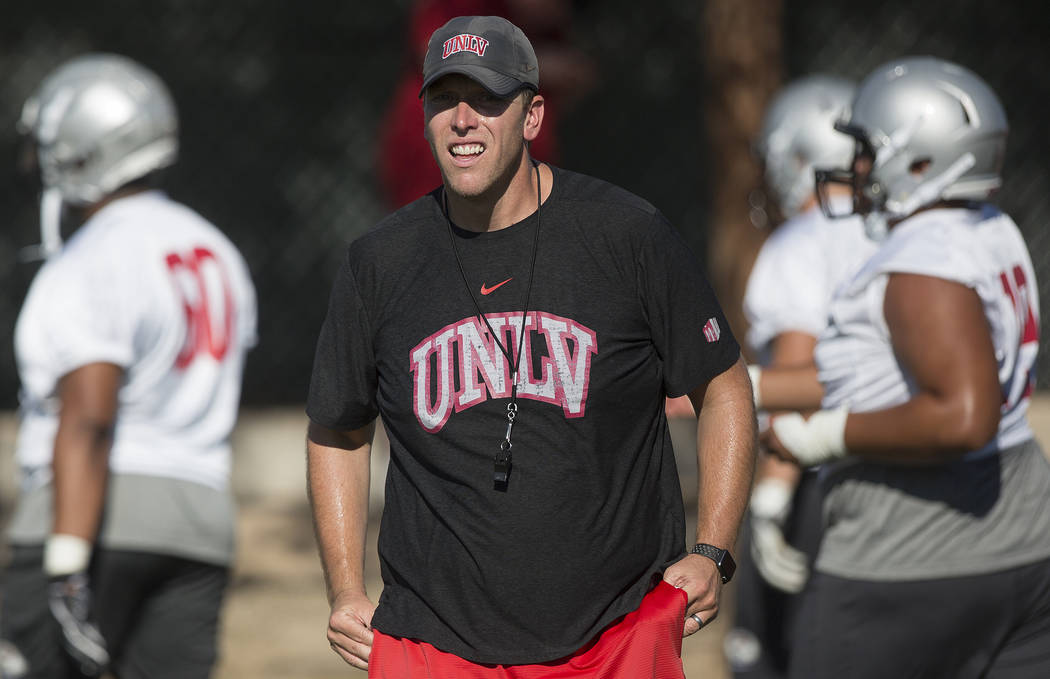 UNLV offensive coordinator Garin Justice, middle, coaches up the Rebels during the first day of ...