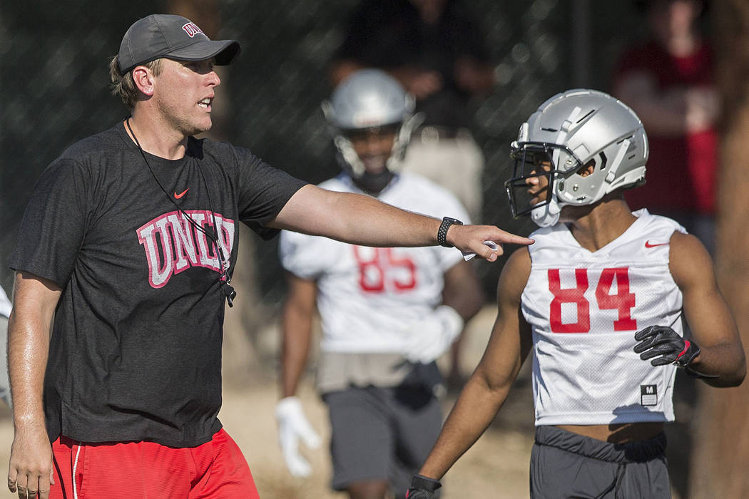 UNLV offensive coordinator Garin Justice, left, talks with wide receiver Steve Jenkins during t ...