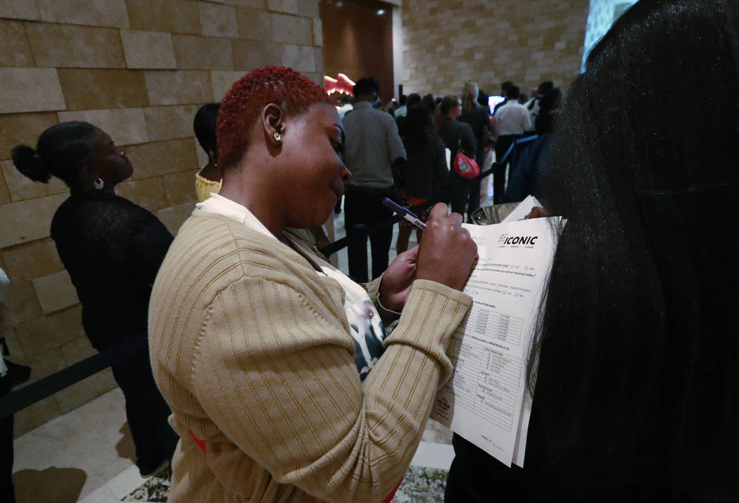 In this June 4, 2019 photo, job applicant Esta Williams, center, uses Tracy Simeton's back to f ...