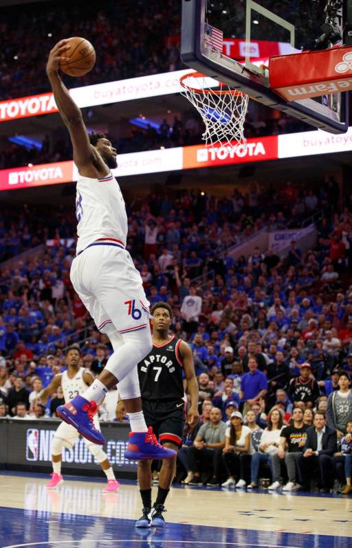 Philadelphia 76ers' Joel Embiid goes up for the dunk as Toronto Raptors' Kyle Lowry watches dur ...