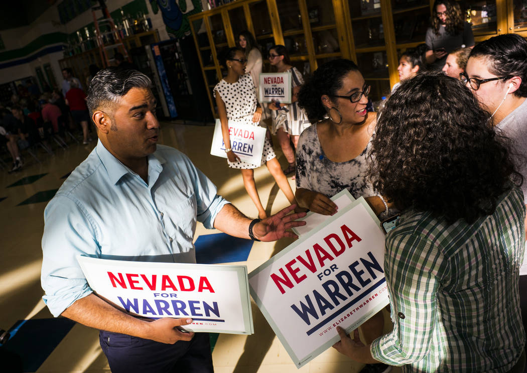 Organizer Richard Ponce, left, hands out signs in support of Democratic presidential candidate ...