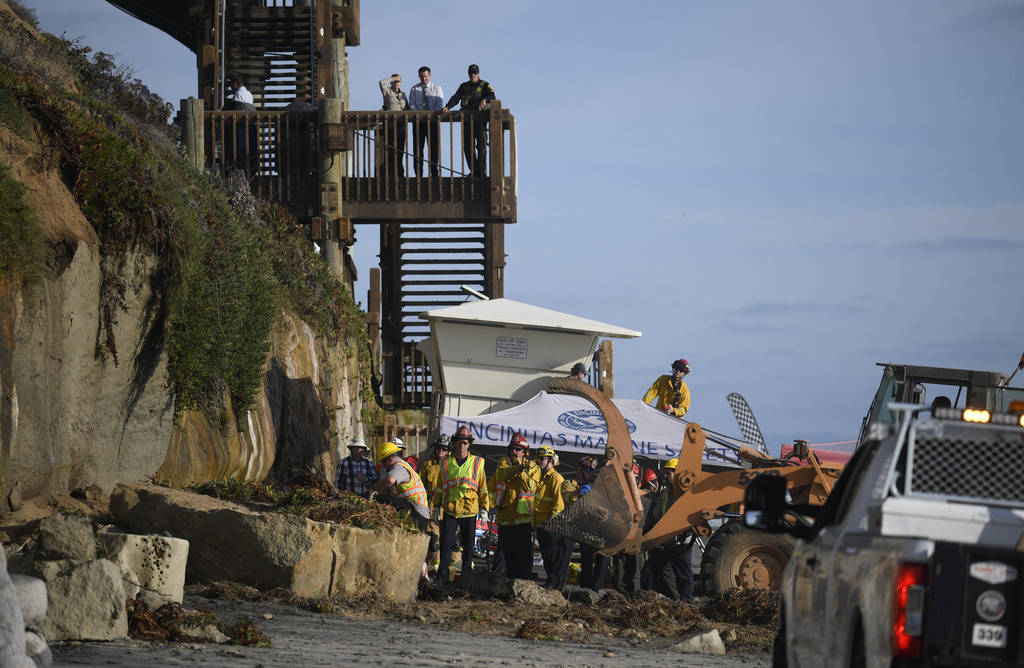 Search and rescue personnel work at the site of a cliff collapse at a popular beach Friday, Aug ...