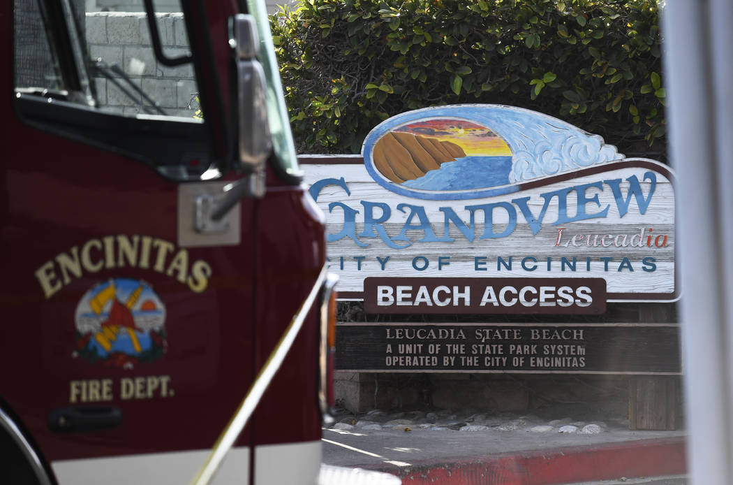 A fire truck sits above the site of a cliff collapse at a popular beach Friday, Aug. 2, 2019, i ...