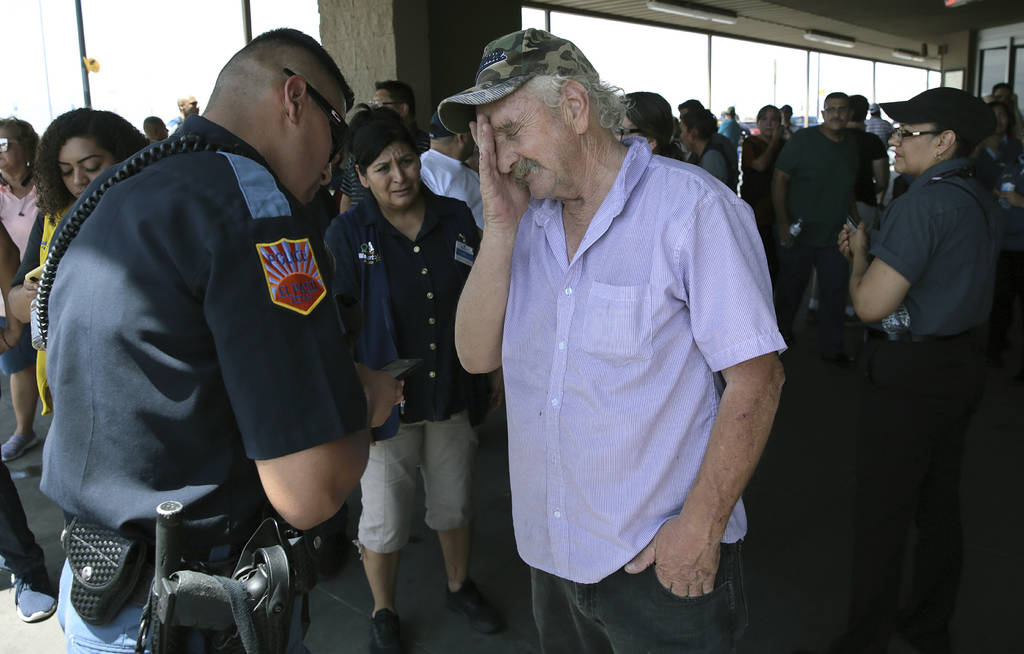 An El Paso Police Officer interviews a witness who was inside the Walmart near the Cielo Vista ...