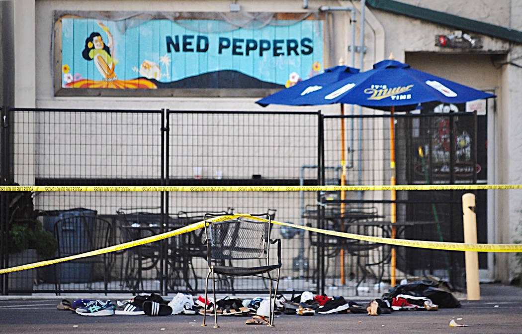 Police tape drapes over a chair near a pile of shoes after a mass shooting in Dayton, Ohio on S ...