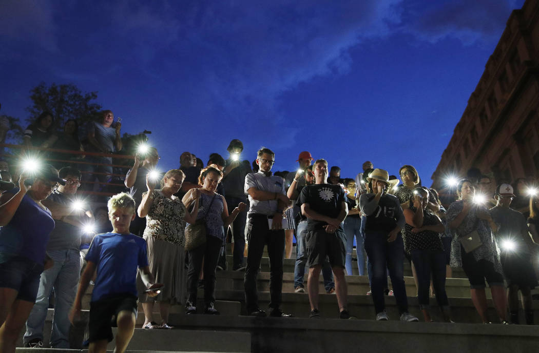 People attend a vigil for victims of the shooting Saturday, Aug. 3, 2019, in El Paso, Texas. A ...