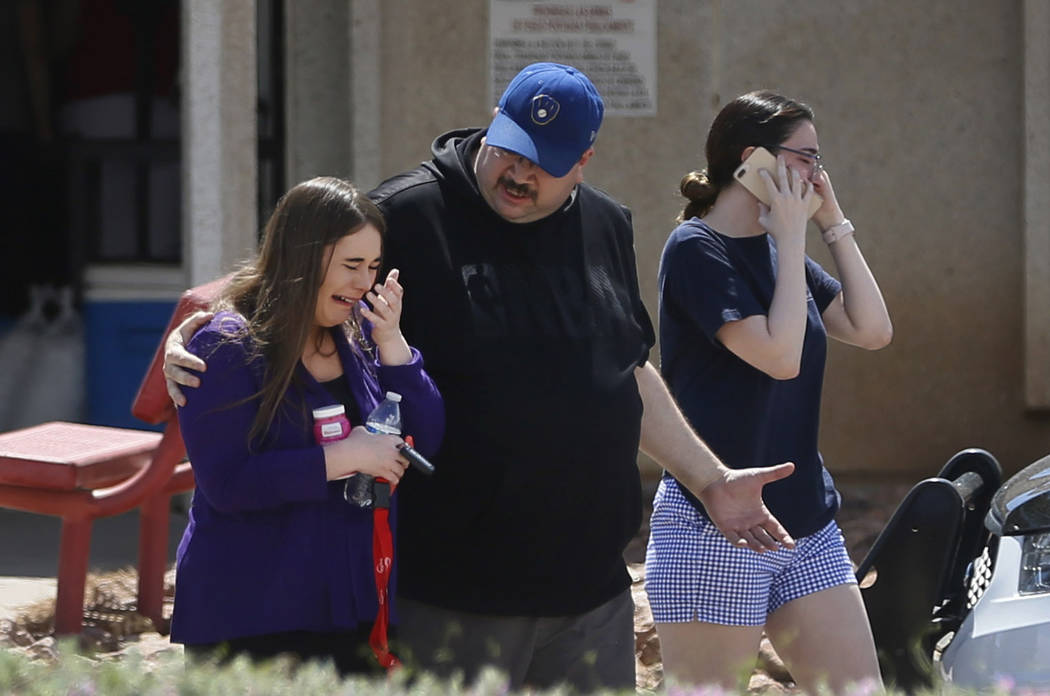 People arrive at MacArthur Elementary looking for family and friends as the school is being use ...