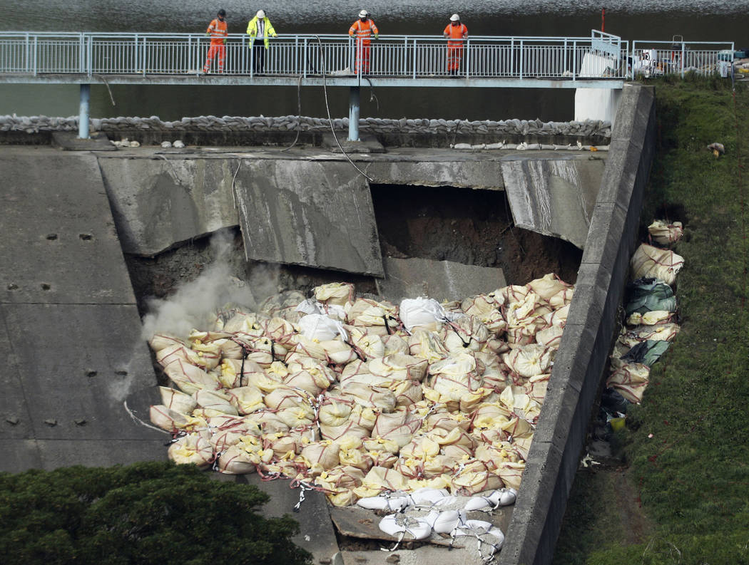 A bag of aggregate, a mixture of sand, gravel and stone, is thrown onto the damaged Toddbrook R ...