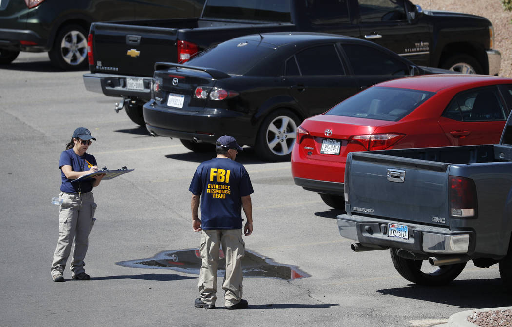 Members of the FBI evidence response team investigate the scene of a mass shooting at a shoppin ...