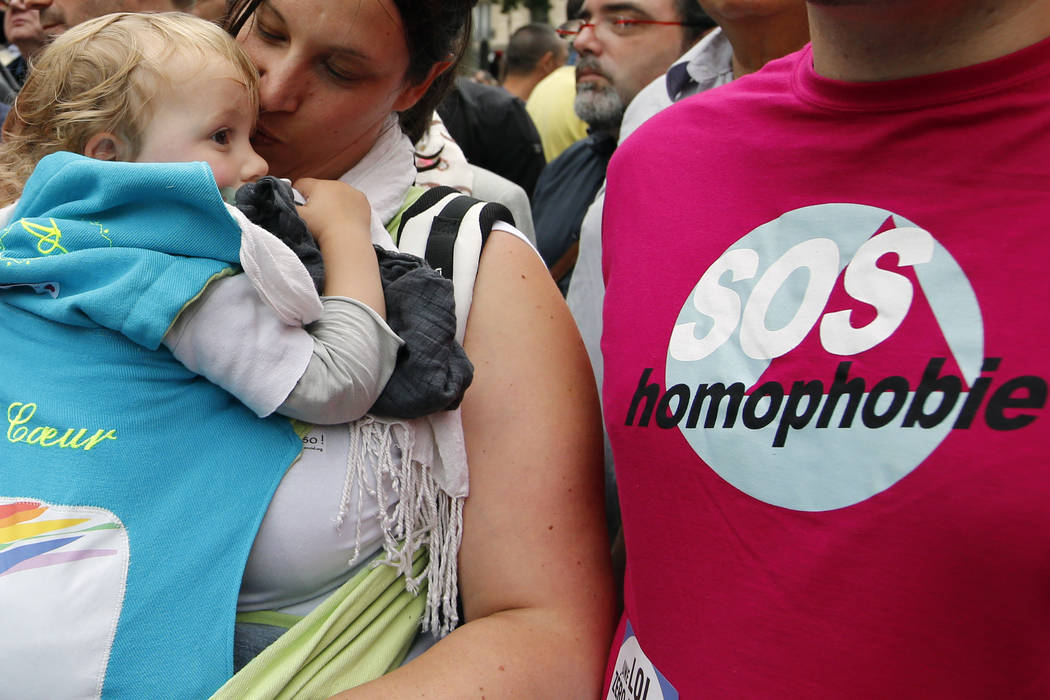 FILE - In this Saturday, June 28, 2014 file photo a woman kisses a baby next to a man wearing a ...