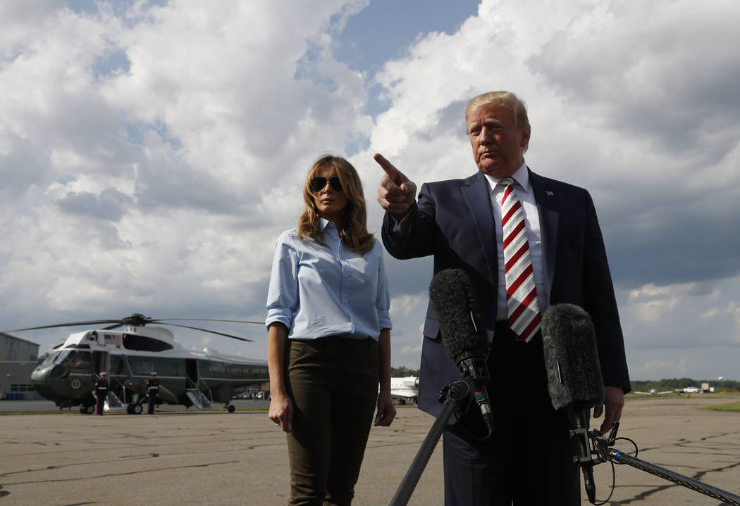 President Donald Trump, with first lady Melania Trump, speaks to the media before boarding Air ...