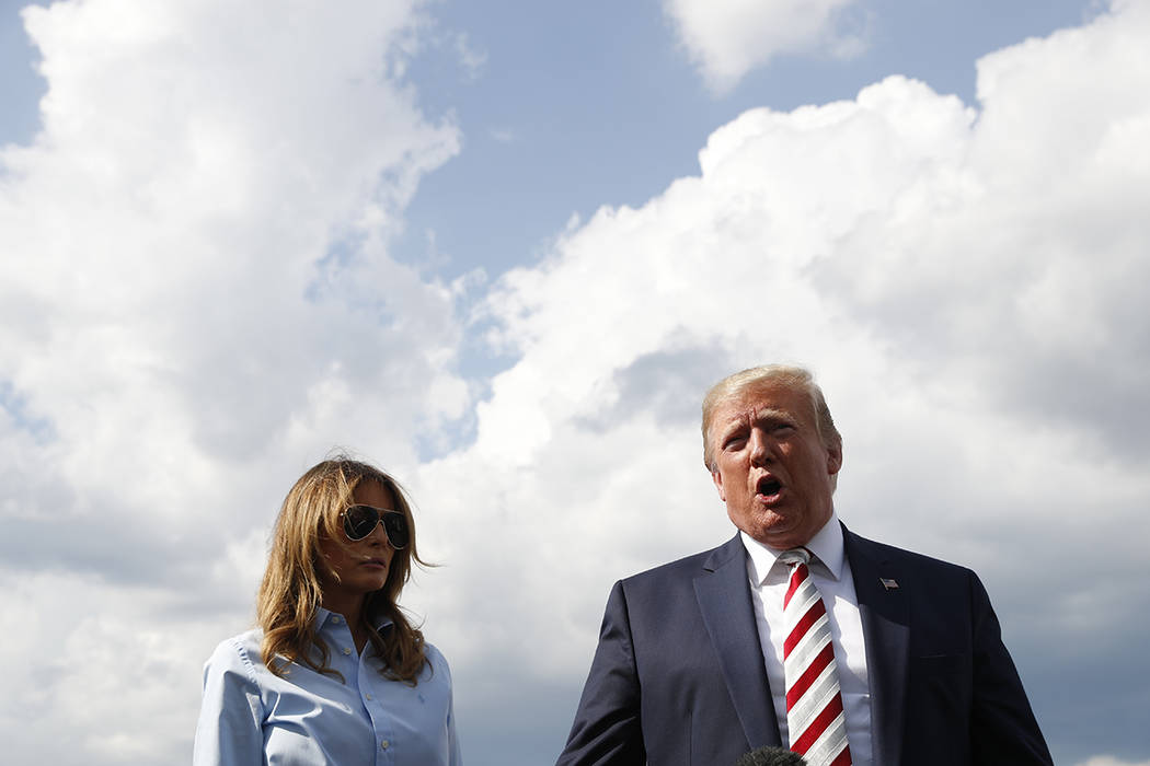 President Donald Trump, with first lady Melania Trump, speaks to the media before boarding Air ...