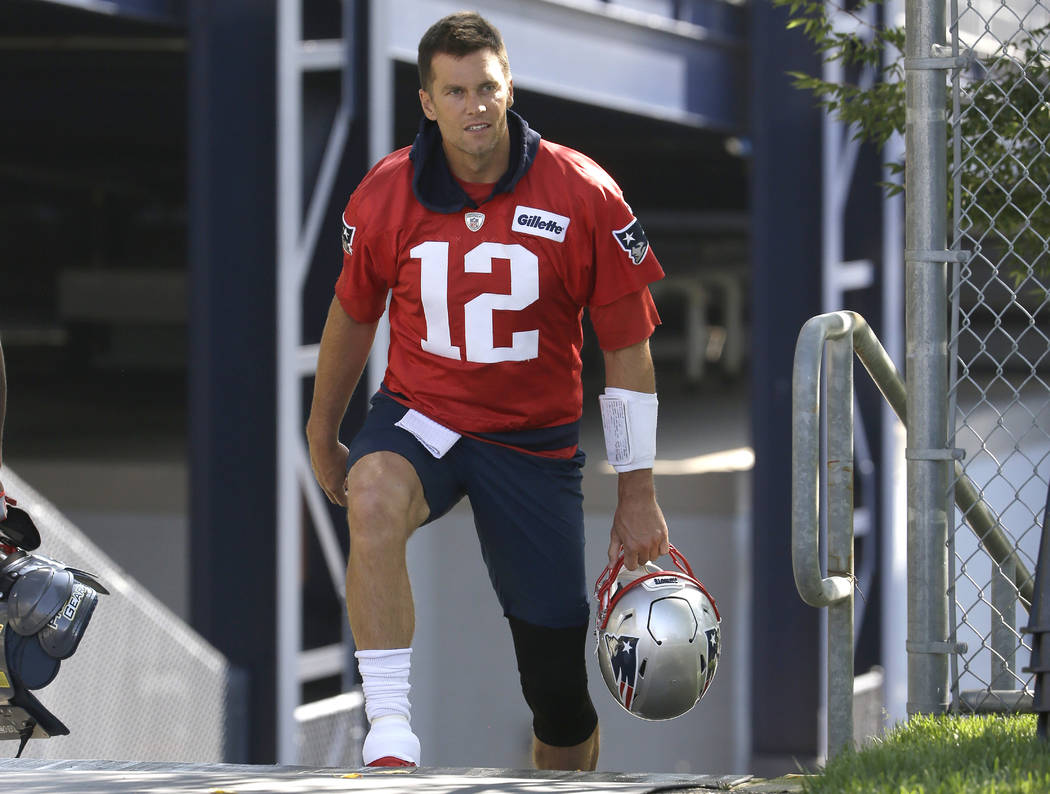 New England Patriots quarterback Tom Brady steps on the field at the start of an NFL football t ...