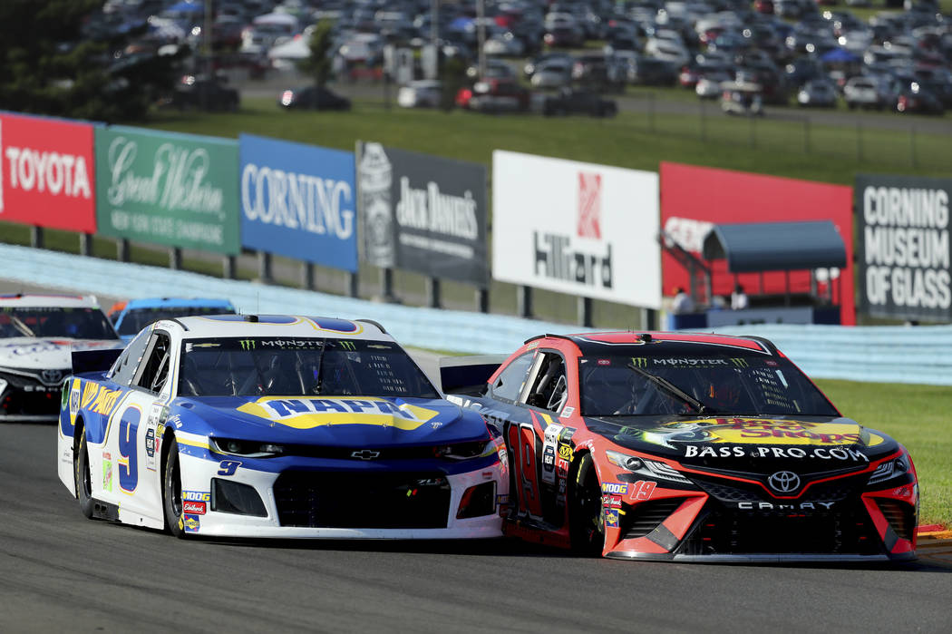 Chase Elliott (9) holds off an attempted pass by Martin Truex, Jr., after a restart following a ...