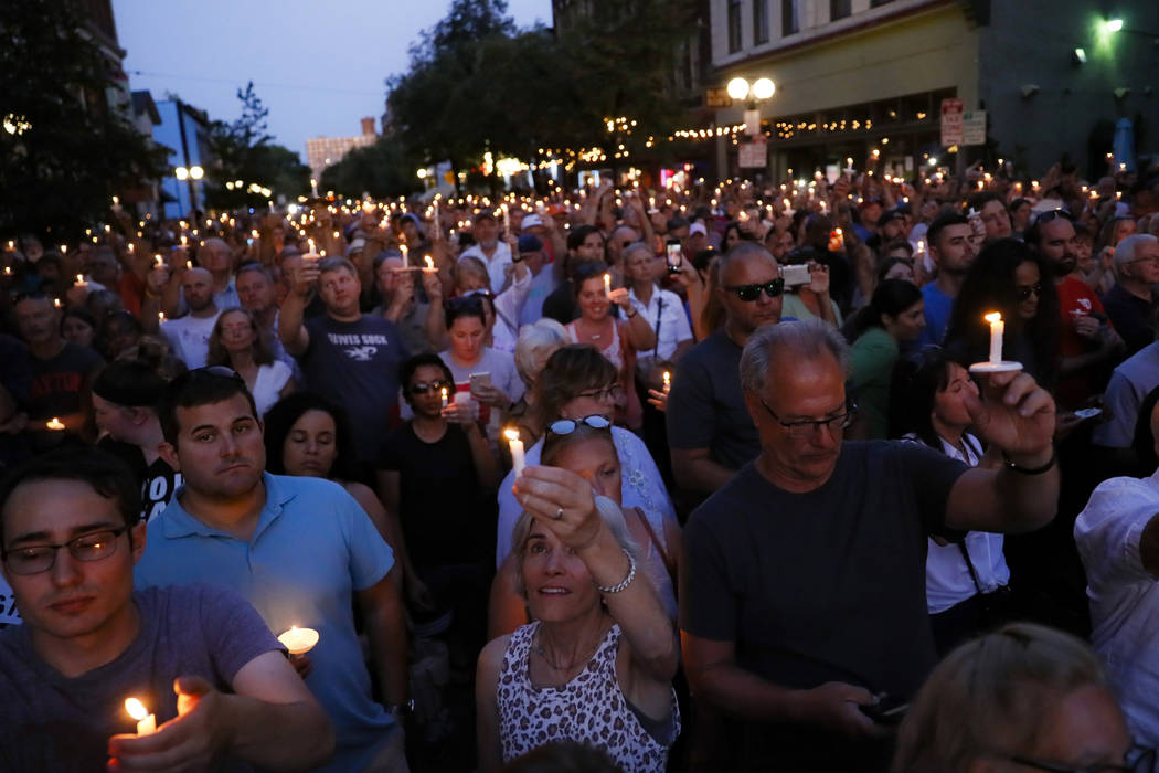 Mourners gather for a vigil at the scene of a mass shooting, Sunday, Aug. 4, 2019, in Dayton, O ...