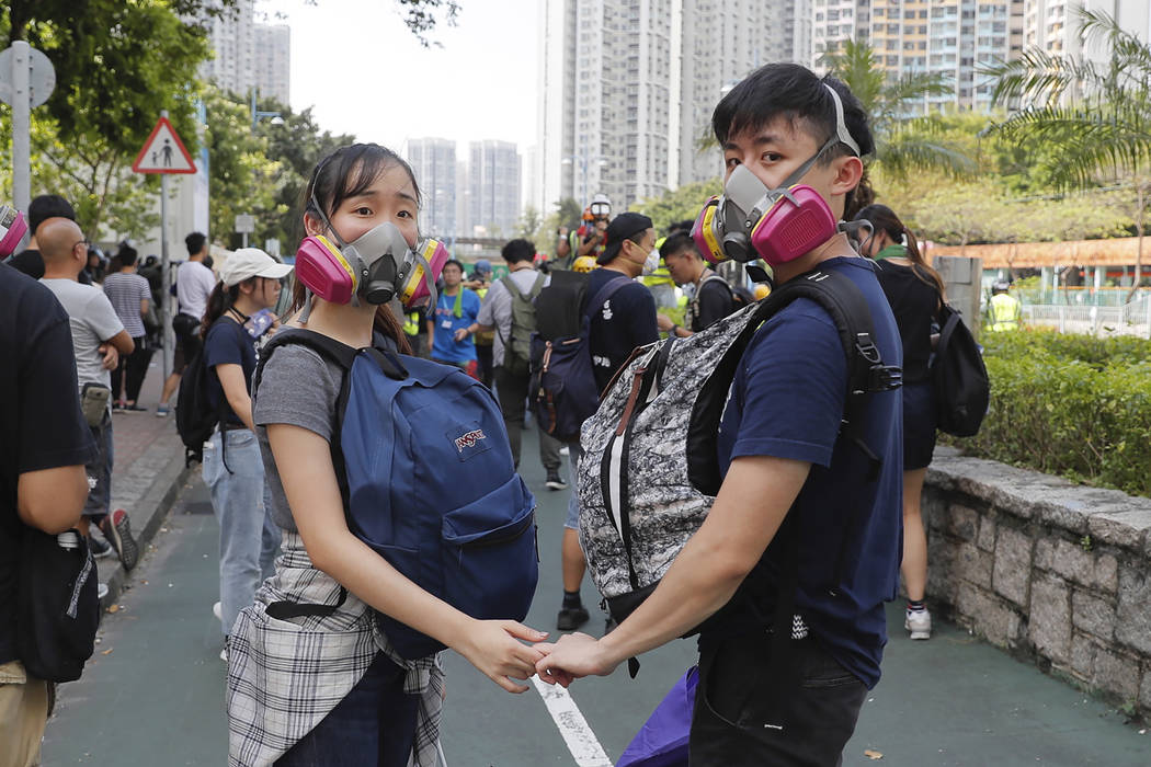 A couple hold hands as they join a protest in Hong Kong on Monday, Aug. 5, 2019. Droves of prot ...