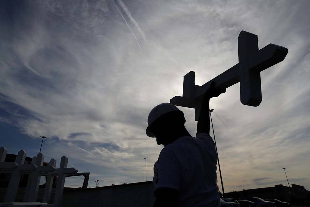 Greg Zanis prepares crosses to place at a makeshift memorial for victims of a mass shooting at ...