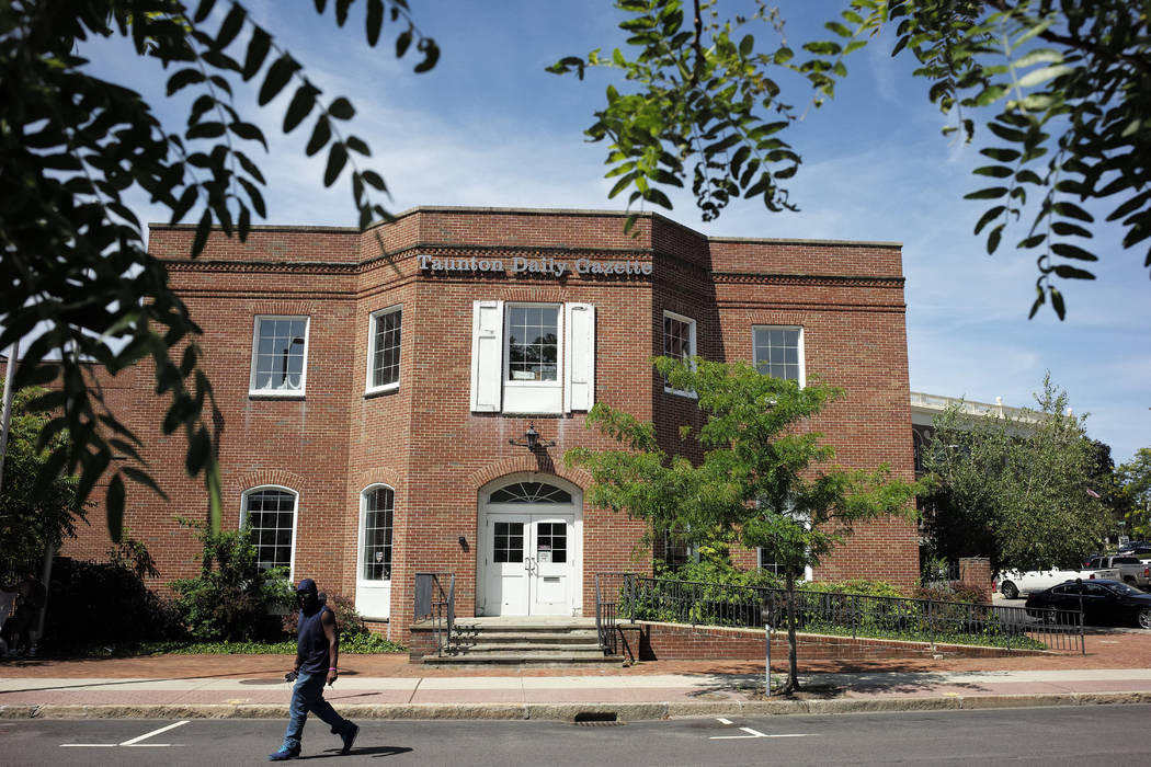 In this Monday, Aug. 5, 2019 photo a passer-by walks near an entrance to the Taunton Daily Gaze ...