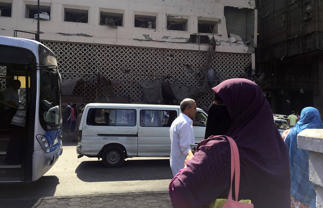 People survey the aftermath of a fiery car crash outside the National Cancer Institute in Cairo ...