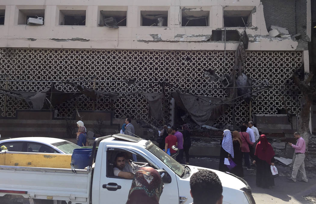 People survey the aftermath of a fiery car crash outside the National Cancer Institute in Cairo ...