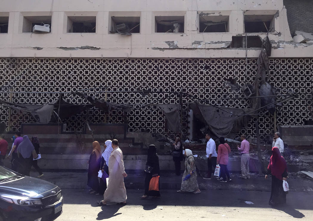 People survey the aftermath of a fiery car crash outside the National Cancer Institute in Cairo ...