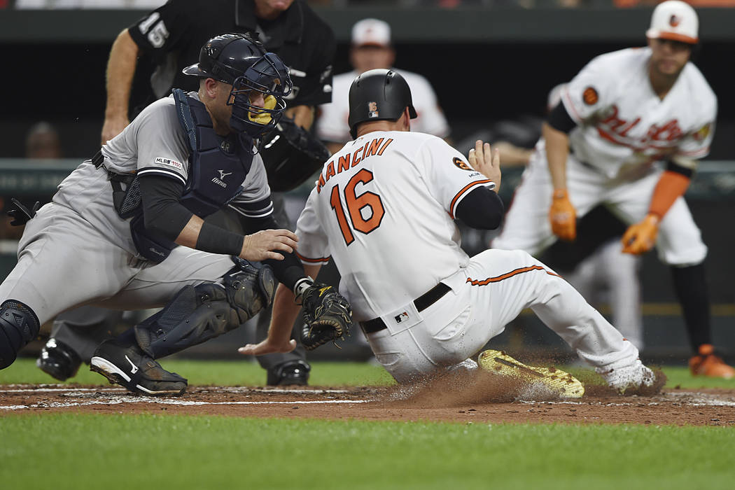 Baltimore Orioles' Trey Mancini (16) is tagged out by New York Yankees catcher Austin Romine, l ...