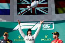 Mercedes driver Lewis Hamilton, center, of Britain, celebrates on the podium with second placed ...