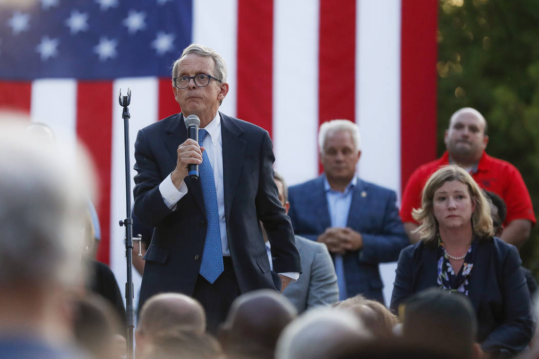 Ohio Gov. Mike DeWine, left, speaks alongside Dayton Mayor Nan Whaley, right, during a vigil at ...